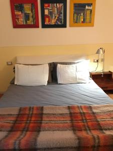 a bed with white pillows and a blanket at Elegante in centro in Imola