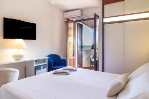 a bedroom with a bed with a view of the ocean at Piccolo Hotel in Castiglione della Pescaia