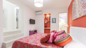 1 dormitorio con 1 cama con sábanas y almohadas coloridas en Rental in Rome Palermo apartment, en Roma