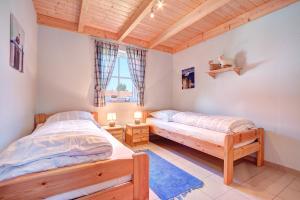 1 Schlafzimmer mit 2 Betten und Holzdecke in der Unterkunft Paradies-Ferien in Burhave