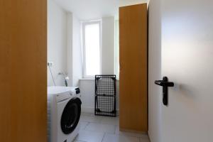 a bathroom with a washing machine and a window at Zentral gelegenes 3 BR Work&Soul Apartment, ideal zum Entspannen und Arbeiten in Neustadt an der Weinstraße