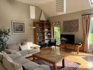 a living room with a couch and a tv at Ballycorrigan Lodge Luxury house for up to 12 guests in Ballina +22 photos