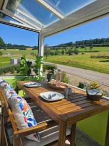 a wooden table on a patio with a view of a field at Apartment Hügelruhe Mandach - 100 m2 - 3 Schlafzimmer - Ferien - Business in Böttstein