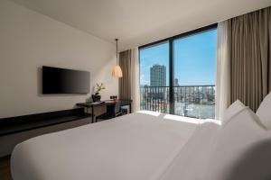 a bedroom with a large white bed and a large window at Caro Premium Danang Hotel in Danang +54 photos
