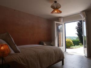 a bedroom with a bed and a sliding glass door at La Nuit Claire in Bellac