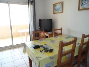 a dining room with a table and a television at Cala di Sognu in Moriani Plage