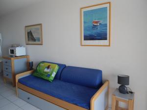 Una habitación con un sofá azul con un juguete. en Cala di Sognu, en Moriani Plage