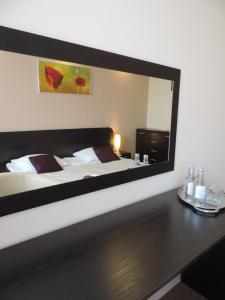 - une chambre avec un grand miroir au-dessus d'un lit dans l'établissement Apartament Green, à Krosno