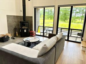 a living room with a couch and a table at Kinagashi Happo Chalet West in Hakuba