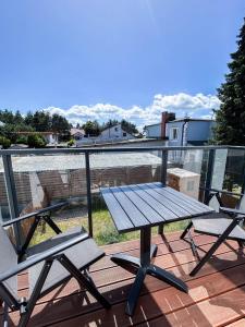 a picnic table and two chairs on a balcony at Ptasi Zakątek M&K Apartamenty - Gdańsk Wyspa Sobieszewska in Gdańsk