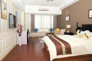 Una habitación de hotel con una cama grande y una sala de estar. en Jiayuan Executive ApartHotel Guangzhou Wuyangcun Metro Station Zhujiang New Town Branch, en Guangzhou