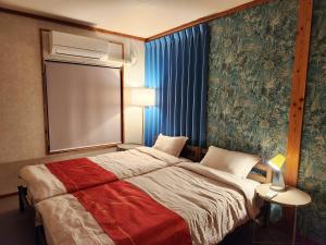 a hotel room with a bed and a window at Casa Yamamoto by Griswood Hotels in Ie