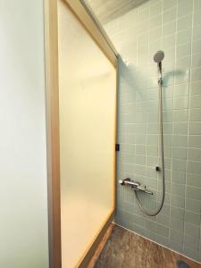 a shower stall with a door in a bathroom at Casa Yamamoto by Griswood Hotels in Ie +19 photos