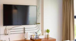 ein Flachbildfernseher, der an einer Wand hängt in der Unterkunft Joy Hotel in Khao Khan Kradaj