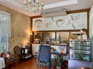 a restaurant with a menu on a wall with drawings on it at Ruen Maihom Riverside Cottage in Ban Tha Nam Tun