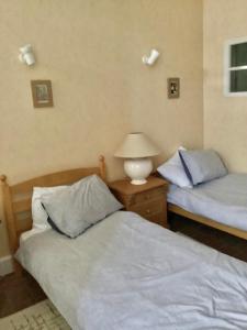 a bedroom with two beds and a lamp on a night stand at Rural House near Sancerre 2 bedrooms in Feux