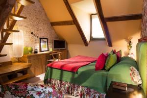 a bedroom with a bed with green and red pillows at Hotel De France in Angerville