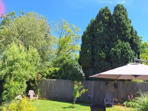 a yard with an umbrella and a fence at Fairytale Memories, gîte, spas et féerie in Varsberg