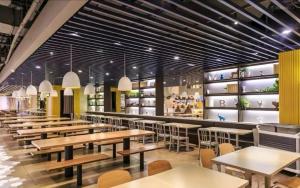un restaurante con mesas y sillas en una cafetería en Jiayuan Executive ApartHotel Guangzhou Wuyangcun Metro Station Zhujiang New Town Branch, en Guangzhou