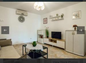 a living room with a couch and a tv at Villa Apartments Babaja in Omiš