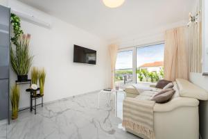 a living room with a white couch and a large window at Three Seas in Maslenica