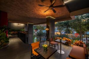 a patio with a ceiling fan and a table and chairs at Caro Premium Danang Hotel in Danang