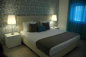 a bedroom with a large bed with two lamps at Hotel Dom Lourenco in Areia Branca