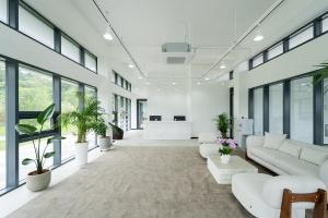an office lobby with white furniture and plants at Kylin Villa resort Jeju in Seogwipo +108 photos