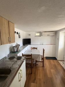 a kitchen with a table and a dining room at Hygge-Kuca in Neum