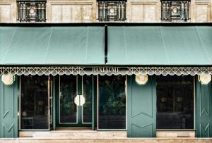 un accès vert à un bâtiment avec un auvent vert dans l'établissement Handsome Hotel, à Paris