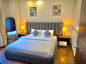 een slaapkamer met een groot bed met twee tafels en twee lampen bij Luxury One Bedroom Apartments -Facing Centaurus Mall Islamabad in Dargai +64 foto's