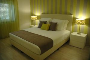 a bedroom with a large bed with two lamps at Hotel Dom Lourenco in Areia Branca