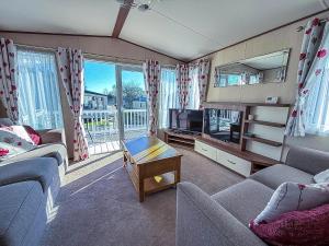 een woonkamer met twee banken en een tv bij Modern Caravan With Decking At Haven Hopton-On-Sea Ref 80032M in Great Yarmouth