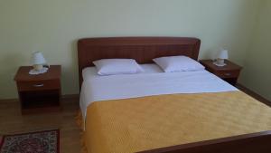ein Schlafzimmer mit einem großen Bett mit zwei Nachttischen in der Unterkunft Apartments Pink house in Povljana