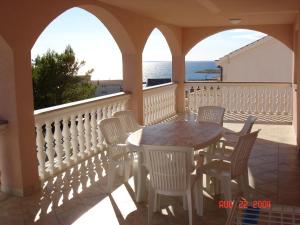 a table and chairs on a balcony with the ocean at Apartments Pink house in Povljana