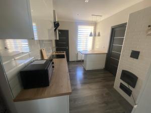 una cucina con forno a microonde sopra un bancone di AV ApartmenT a Rēzekne Altre 3 foto
