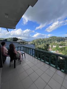 due persone sedute su un balcone che guardano il panorama di Sunbloom Hostel a Kandy