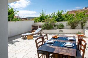 a patio with a table and chairs on a roof at Maison Petra in Santa Teresa Gallura