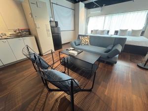 salon z kanapą, stołem i krzesłami w obiekcie Neighbor's Hotel 西広島駅前 w mieście Hiroszima