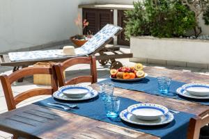 a wooden table with a plate of fruit on it at Maison Petra in Santa Teresa Gallura +12 photos