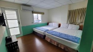 A bed or beds in a room at Lanyu Gulu Homestay