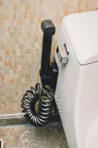 a phone is hanging on the side of a toilet at The Garden Hotel Guangzhou - Discover 26 cultural treasures with hotel Golden Tour Guide in Guangzhou