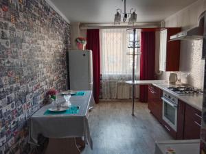 a small kitchen with a table and a refrigerator at 2-х комнатная квартира in Aktobe