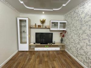 a living room with a flat screen tv on a wall at 2-х комнатная квартира in Aktobe