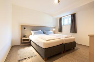 a bedroom with a large bed in a room at Gästehaus Strasser in Riezlern