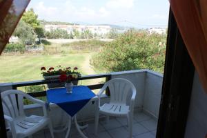 a table and two chairs on a balcony with a view at Villa Iris Studios in Ormos Panagias