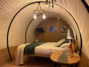 Un dormitorio con una cama y una mesa en una habitación. en White Spring Glamping, en Câmpulung Moldovenesc