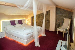 a bedroom with a canopy bed and a chair at Boriki Complex in Pamporovo