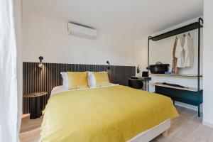 a bedroom with a large bed with a yellow blanket at Appart Hotel Neostelia in Annecy