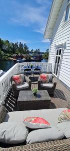 a deck with couches and tables on a house at Boat Included, Waterfront Villa, Near Bergen in Lindås +51 photos